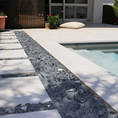 Piscine noire et blanche avec des pièces de porcelaine sur des cailloux