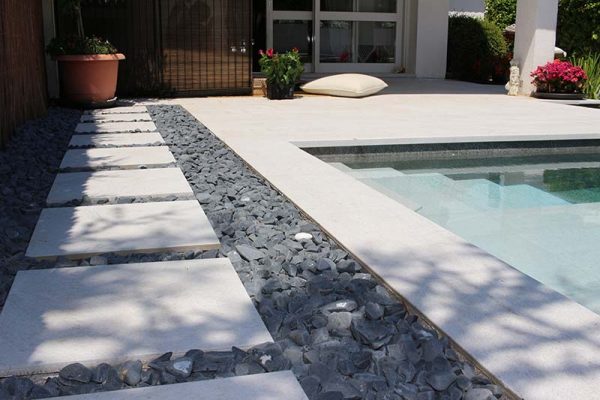 Black and white pool with porcelain pieces on pebbles