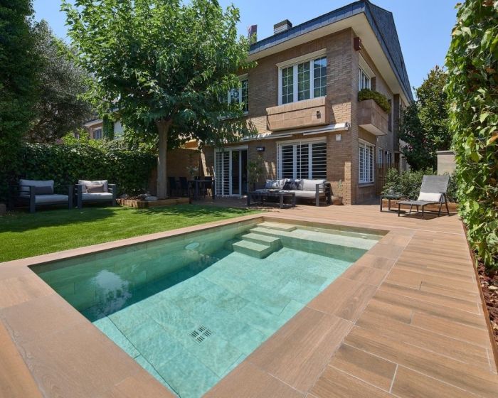 Piscina pequeña con diseño en gres porcelánico, entorno coherente entre vaso, borde y pavimento exterior